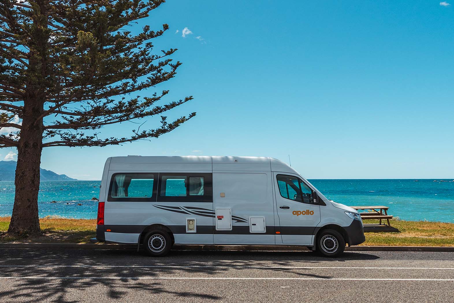 Apollo Camper at a New Zealand beach on a blue sky summer day